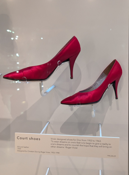 a pair of bright red court shoes with stiletto heels in a display cabinet.